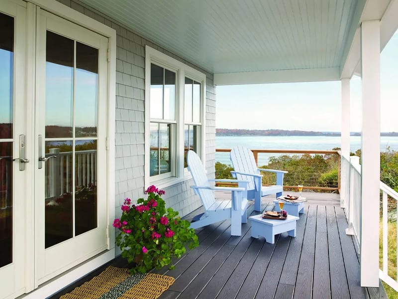 A glazed patio door and windows opening onto a covered porch above the water